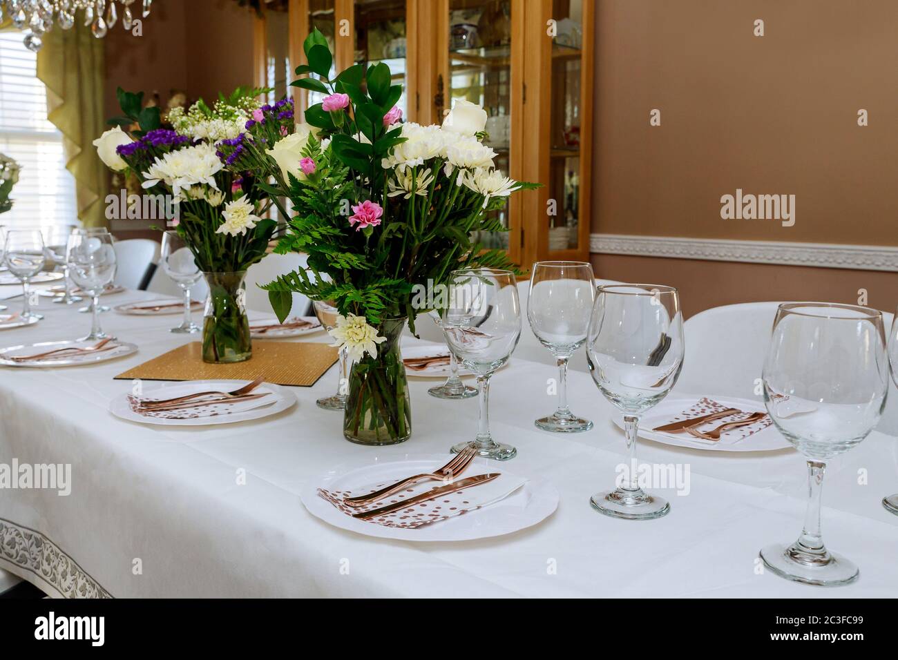 Empty glasses set on festive table with flowers for some event Stock Photo