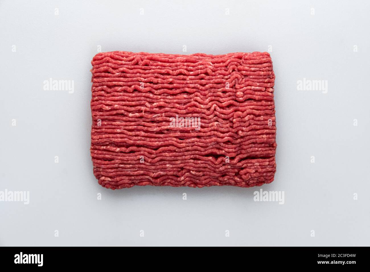 Slab of raw lean ground beef, right out of the grinder on a butchers table Stock Photo