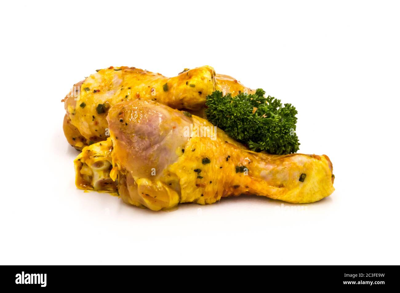 Chicken drumsticks marinate with parsley on a white background Stock