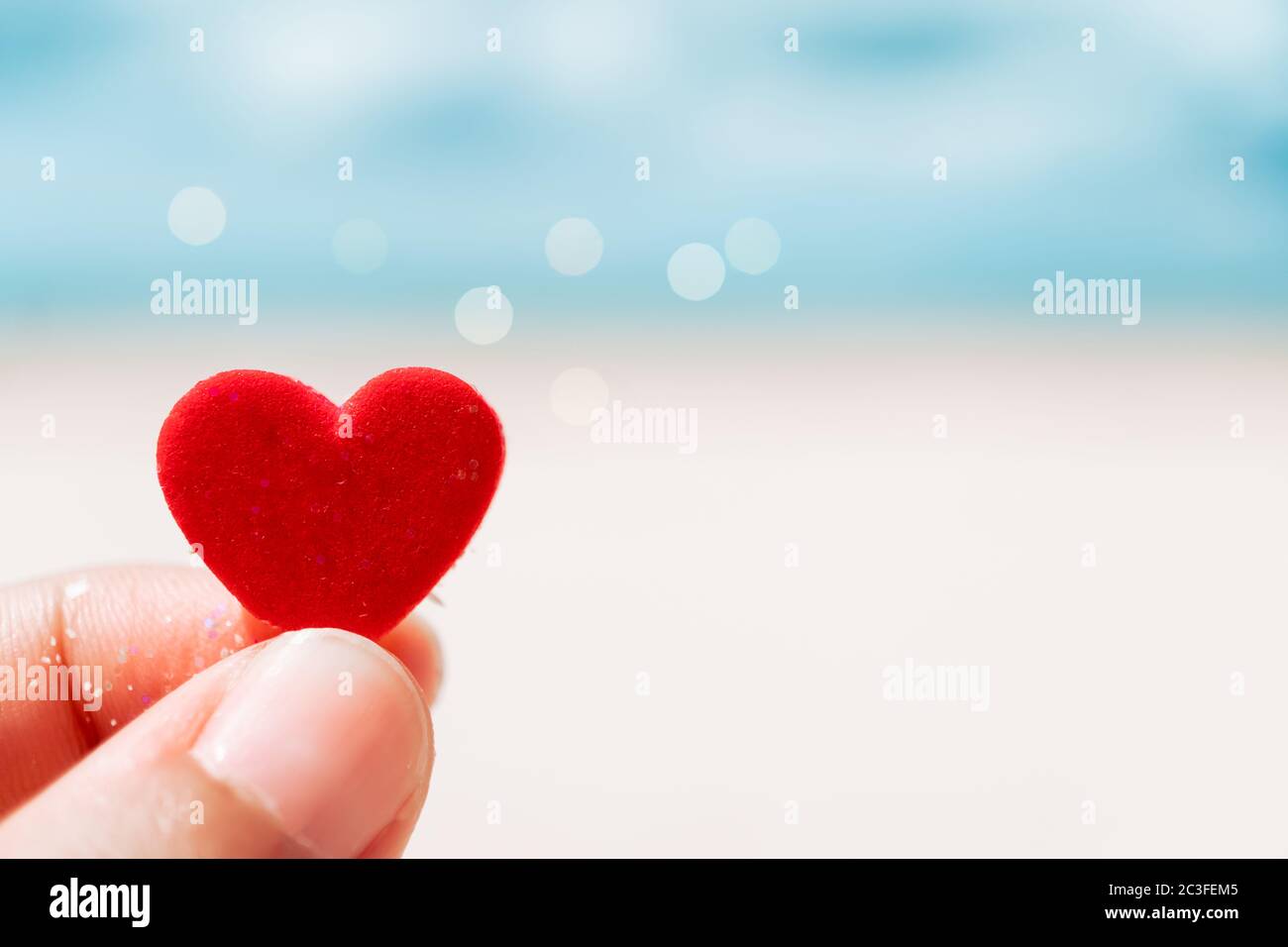 Hand hold little heart meaning feel love with summer beach with blue sky  background Stock Photo - Alamy