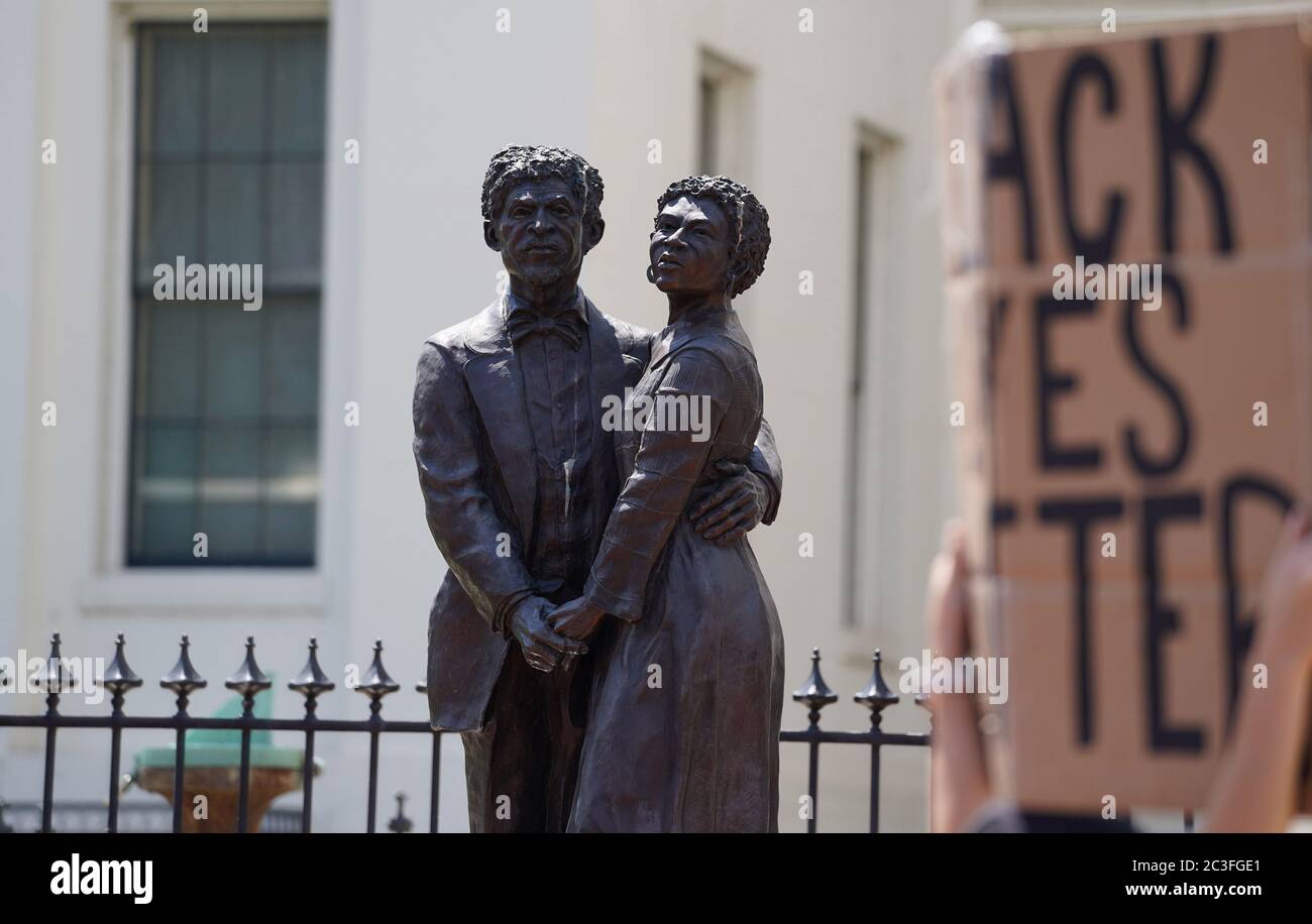 St. Louis, United States. 19th June, 2020. The statue of Dred Scott and his wife Harriet Robinson Scott, stand outside of the Old Courthouse as marchers with signs, pass by in St. Louis on Friday, June 19, 2020. Originating in Texas, Juneteenth is a holiday celebrating the emancipation of those who had been enslaved in the United States. Photo by Bill Greenblatt/UPI Credit: UPI/Alamy Live News Stock Photo