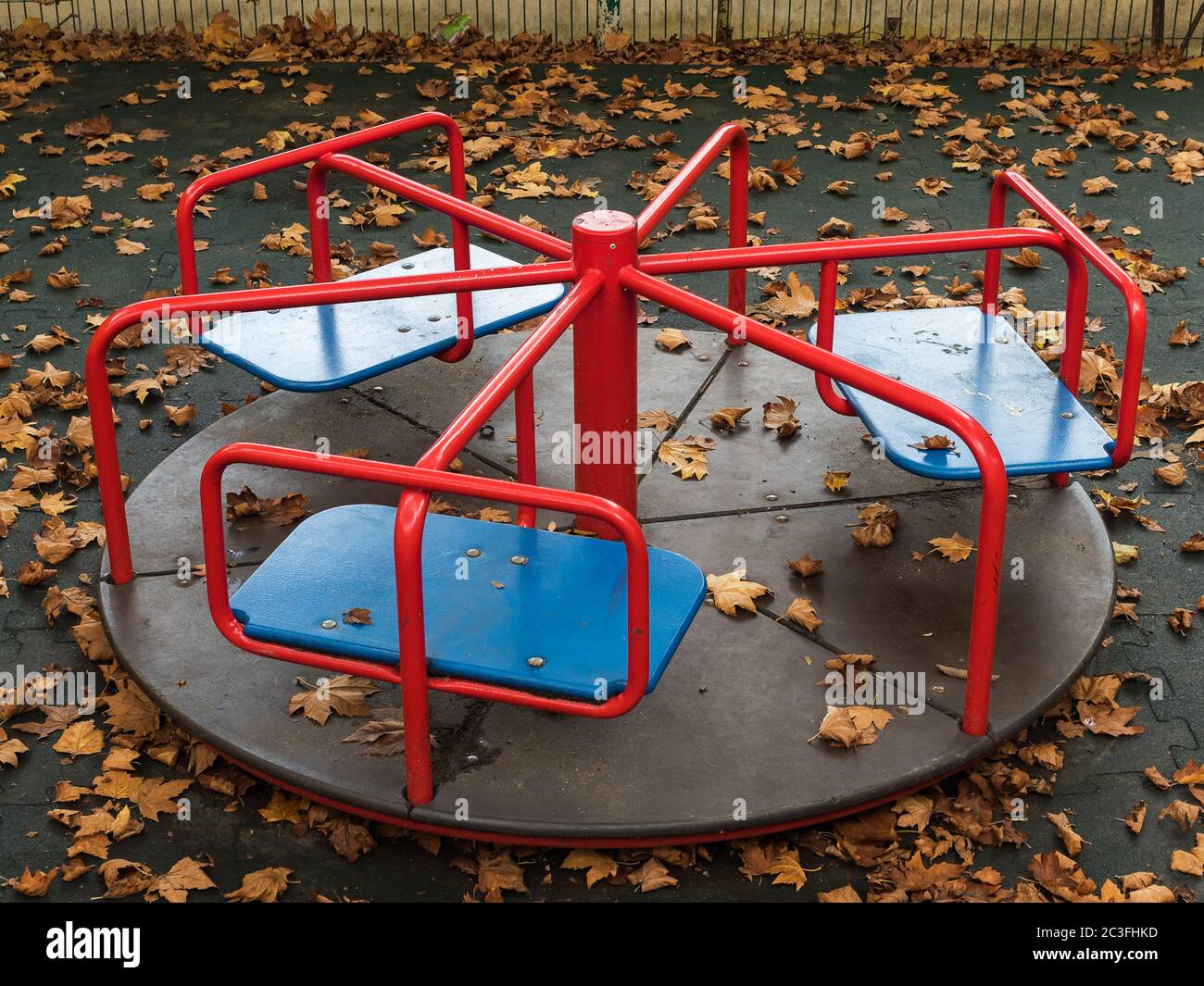 Round swing in the playground covered with yellow leaves Stock Photo