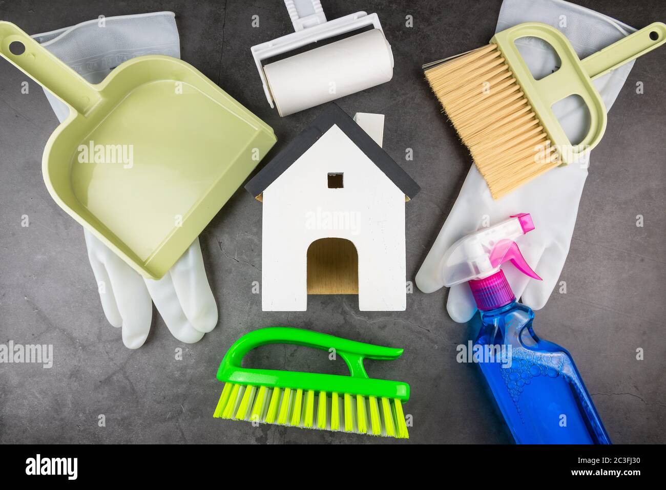 Wooden model white houses and house cleaning equipment on cement gray