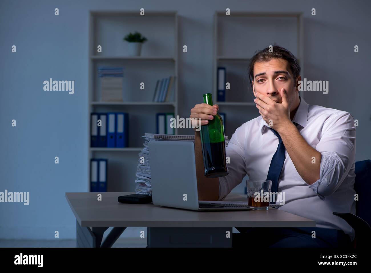 Alcohol addicted businessman working late in the office Stock Photo - Alamy