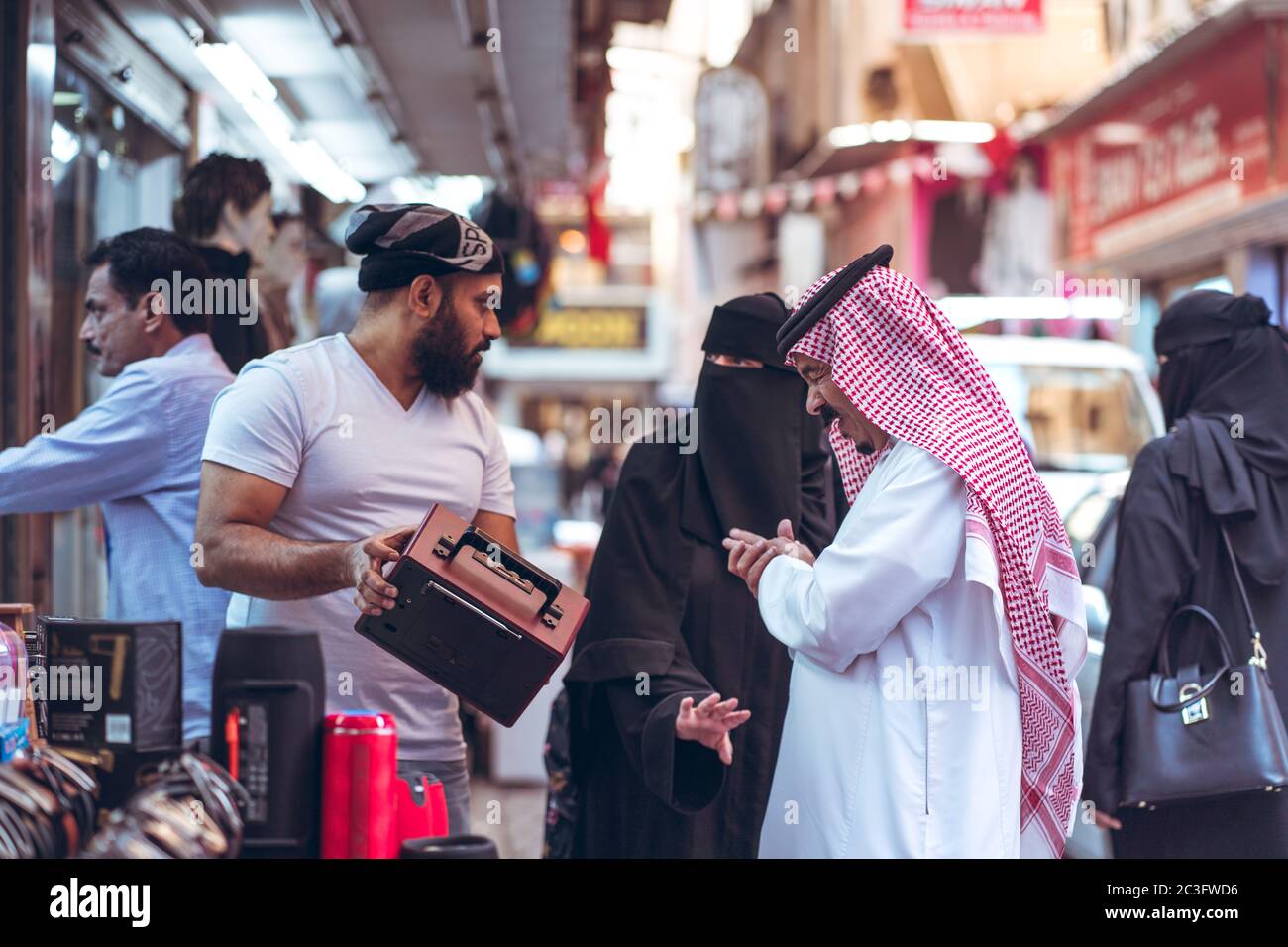 Manama / Bahrain - January 10, 2020: Local Muslim people wearing traditional clothes shopping in Manama Souq, also a famous tourist destination in the capital of Bahrain Stock Photo