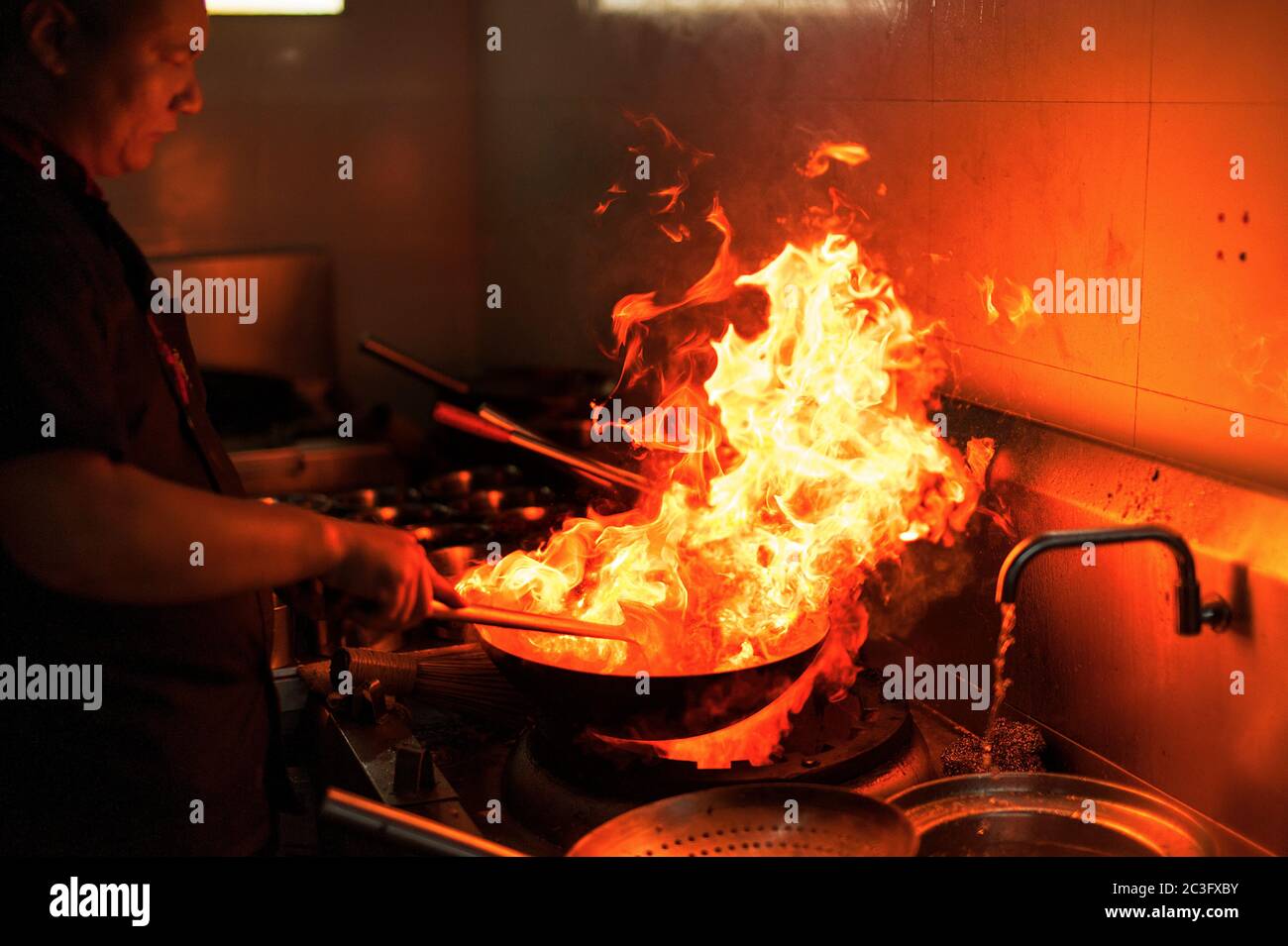 Pictures Chinese cook preparing food on fire in a restaurant kitchen