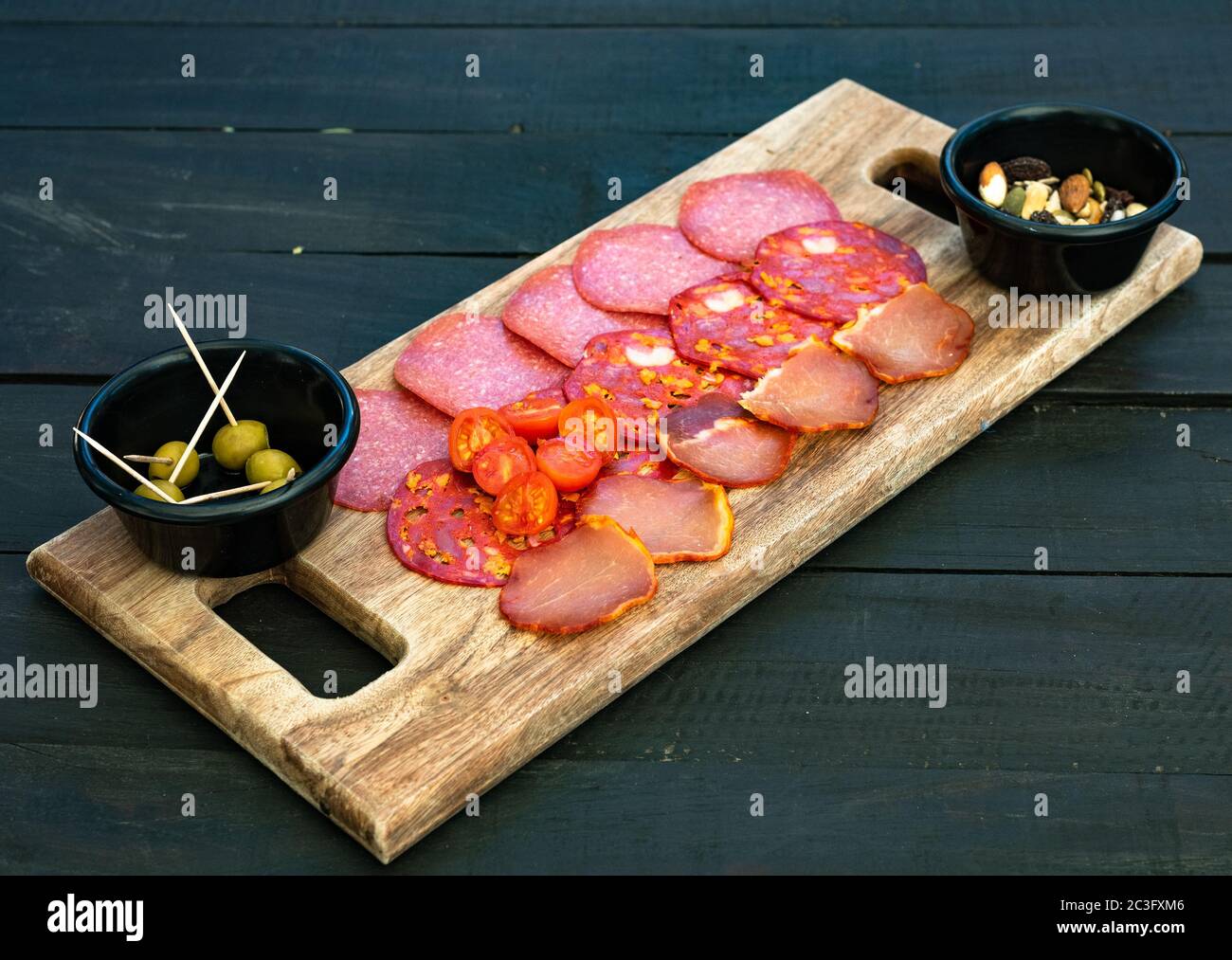 Cured meat platter. Chorizo, salami, ham, olives on a wooden board. Stock Photo