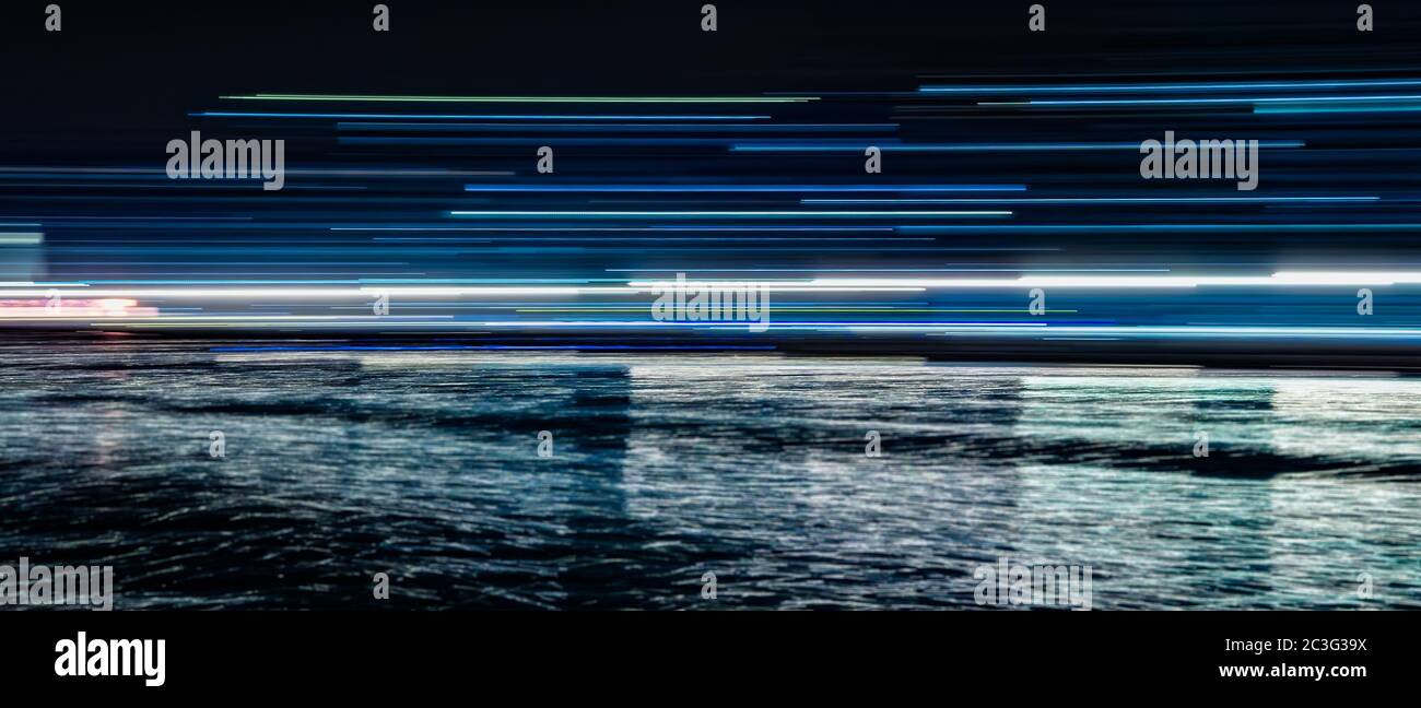Abstract blue light trails reflected in the water Stock Photo - Alamy