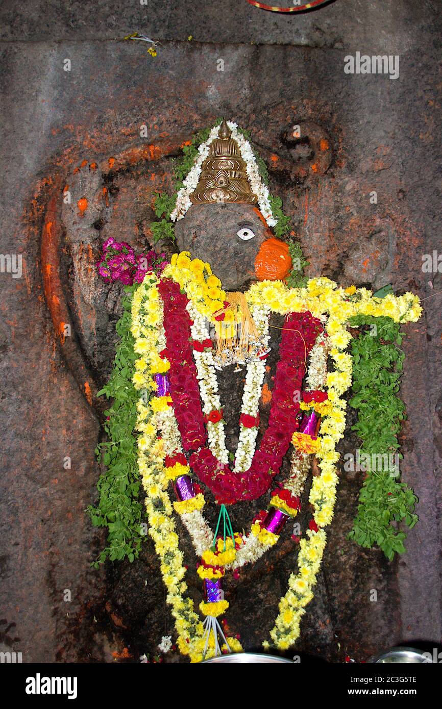 Bas relief sculpture of Anjaneya, decked with flowers and Tulsi leaves, at Ramagiri near Ramanagara, Karnataka, India, Asia Stock Photo