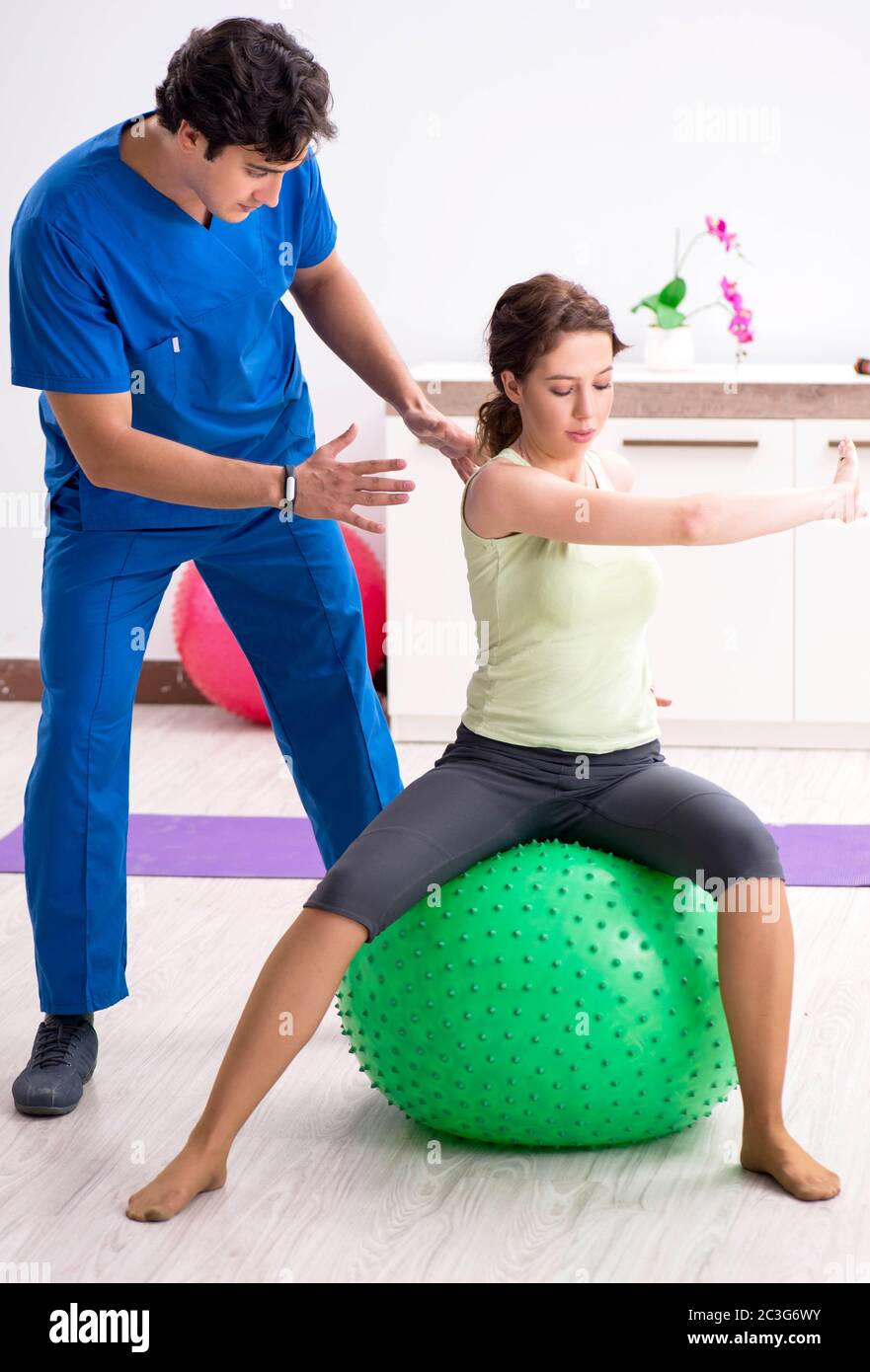Fitness instructor helping sportsman during exercise Stock Photo - Alamy