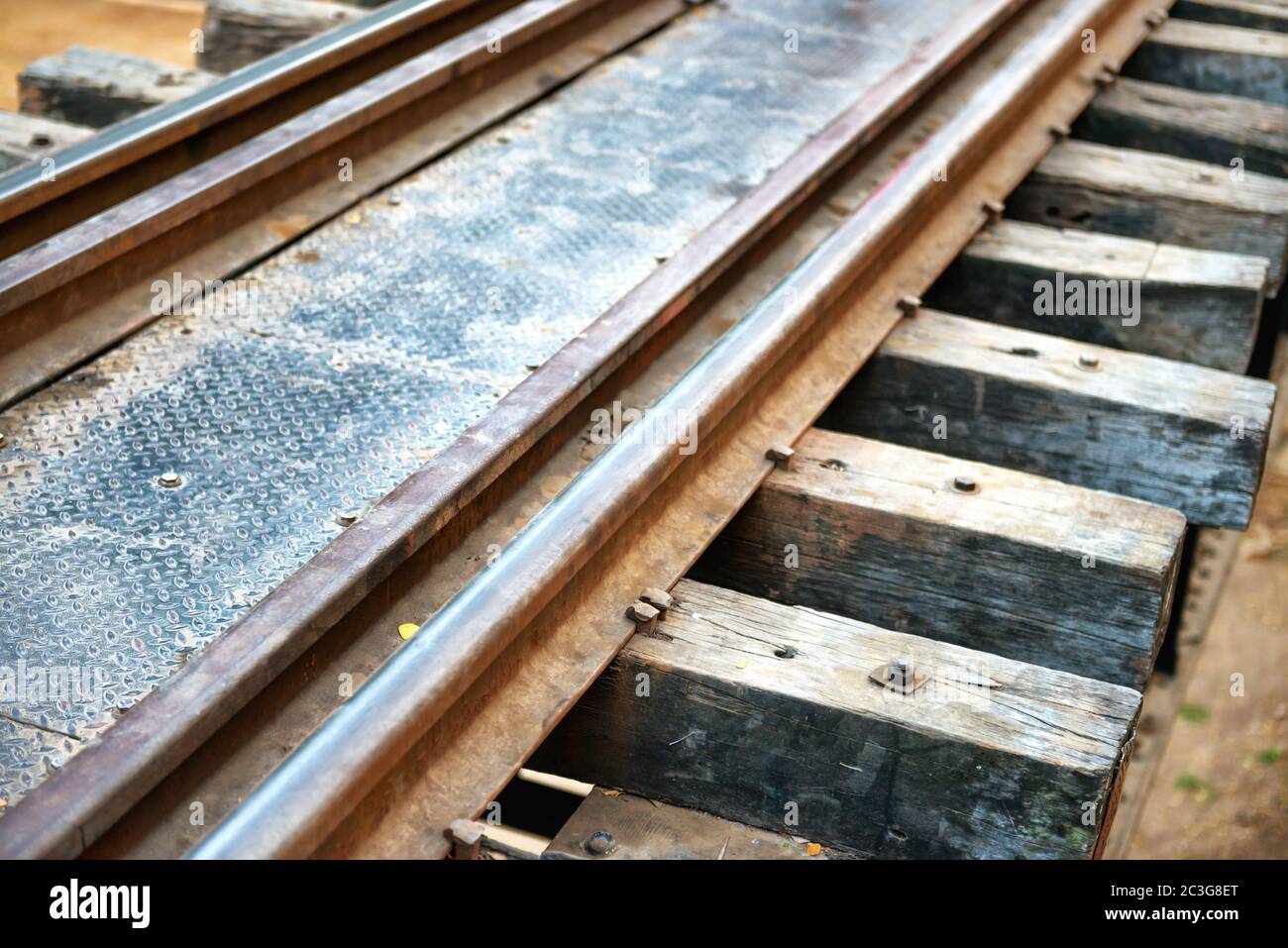 Old rail track with wooden sleepers and rusty rails Stock Photo