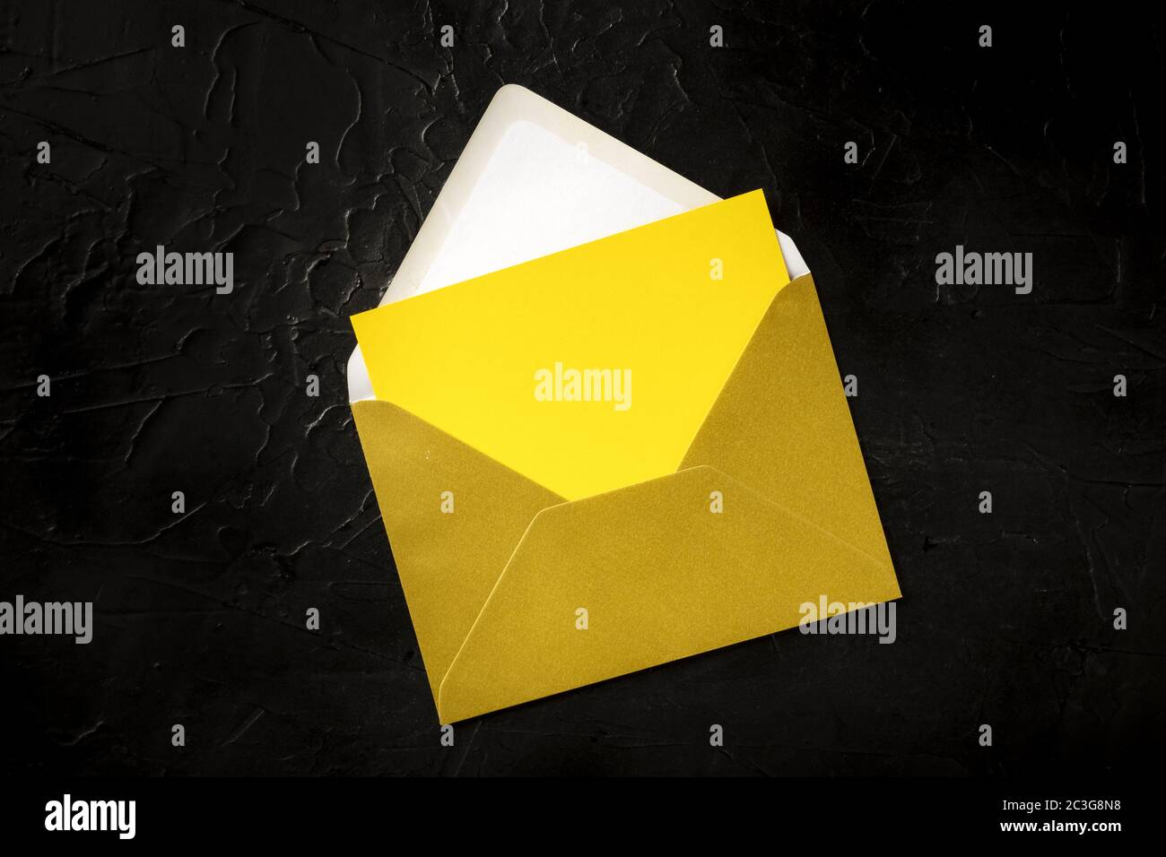 A yellow greeting card in a golden envelope mock-up, shot from the top ...