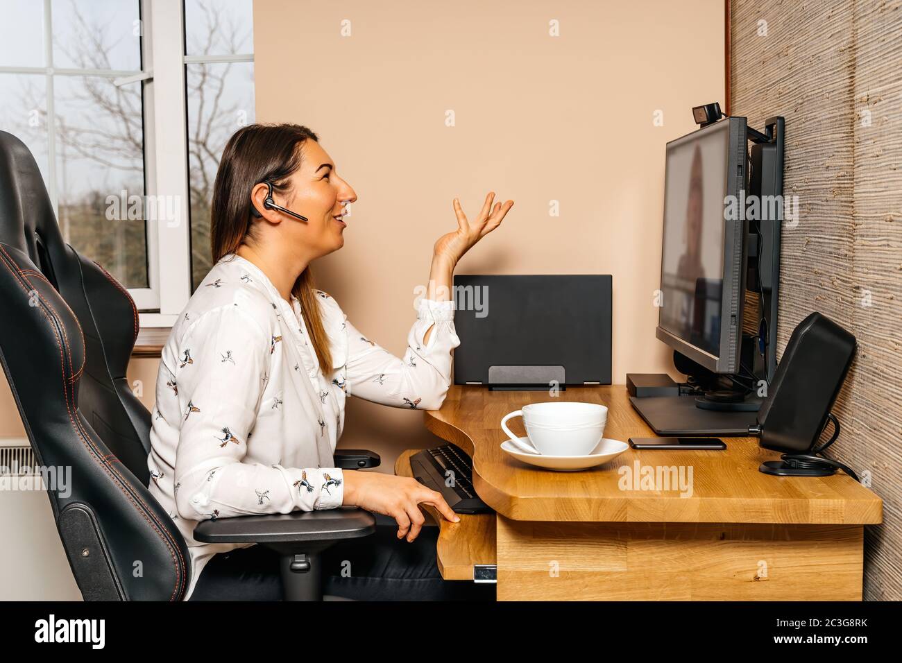 Businesswoman talking on video conference from comfort of her home during coronavirus pandemics and Stock Photo