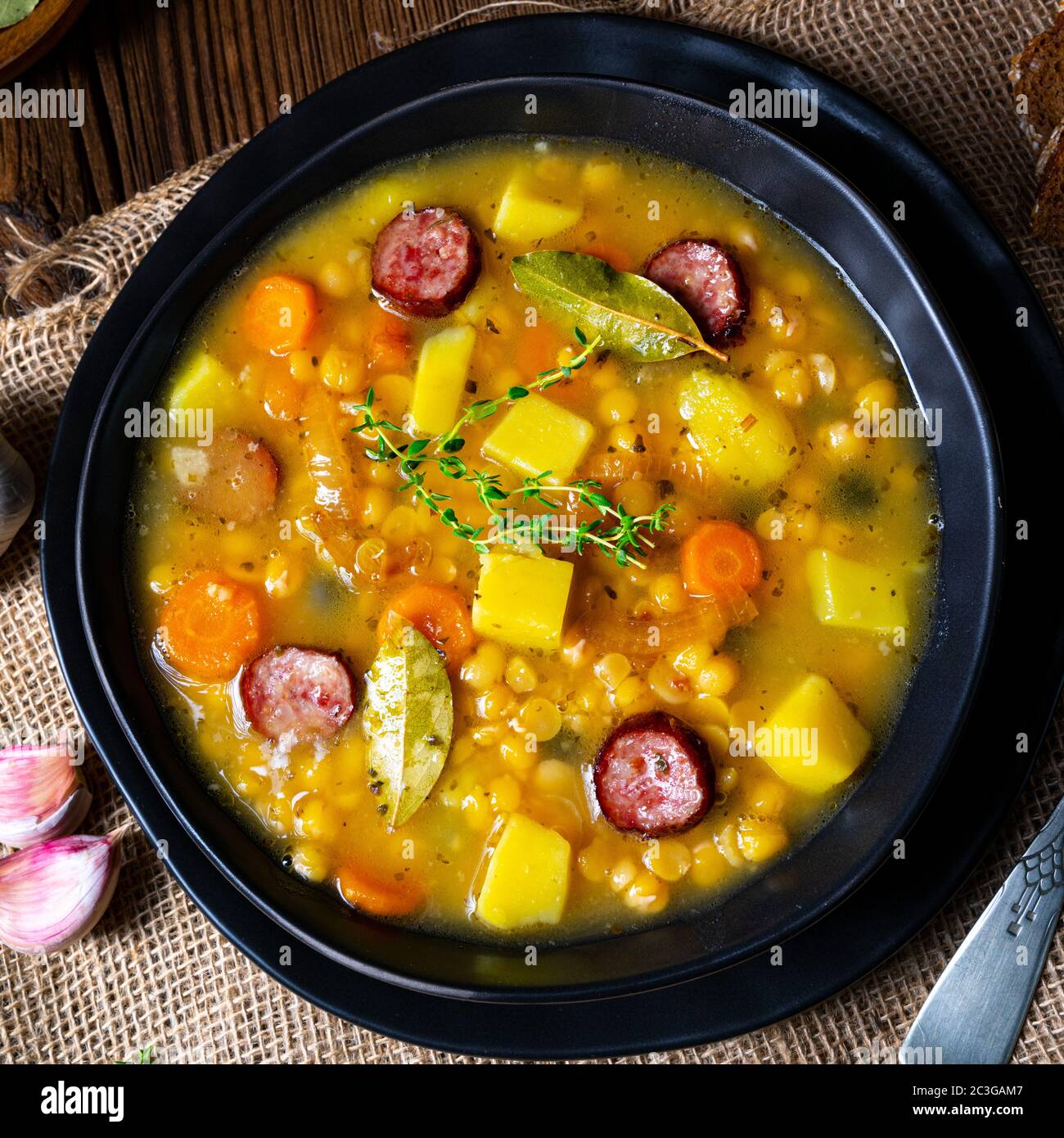 Rustic pea soup with bacon and sausages Stock Photo