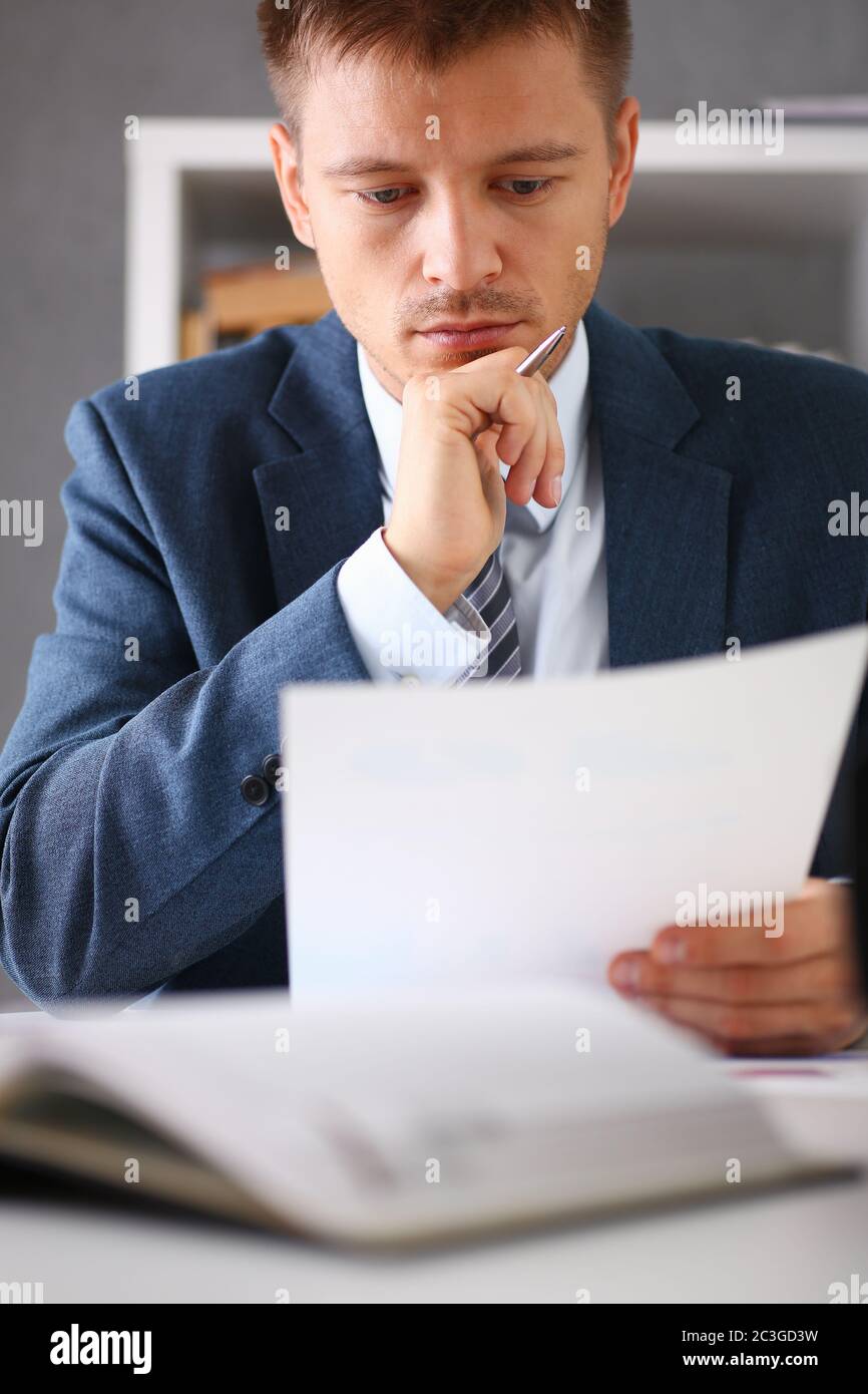 Serious businessman in the office examines documents Stock Photo