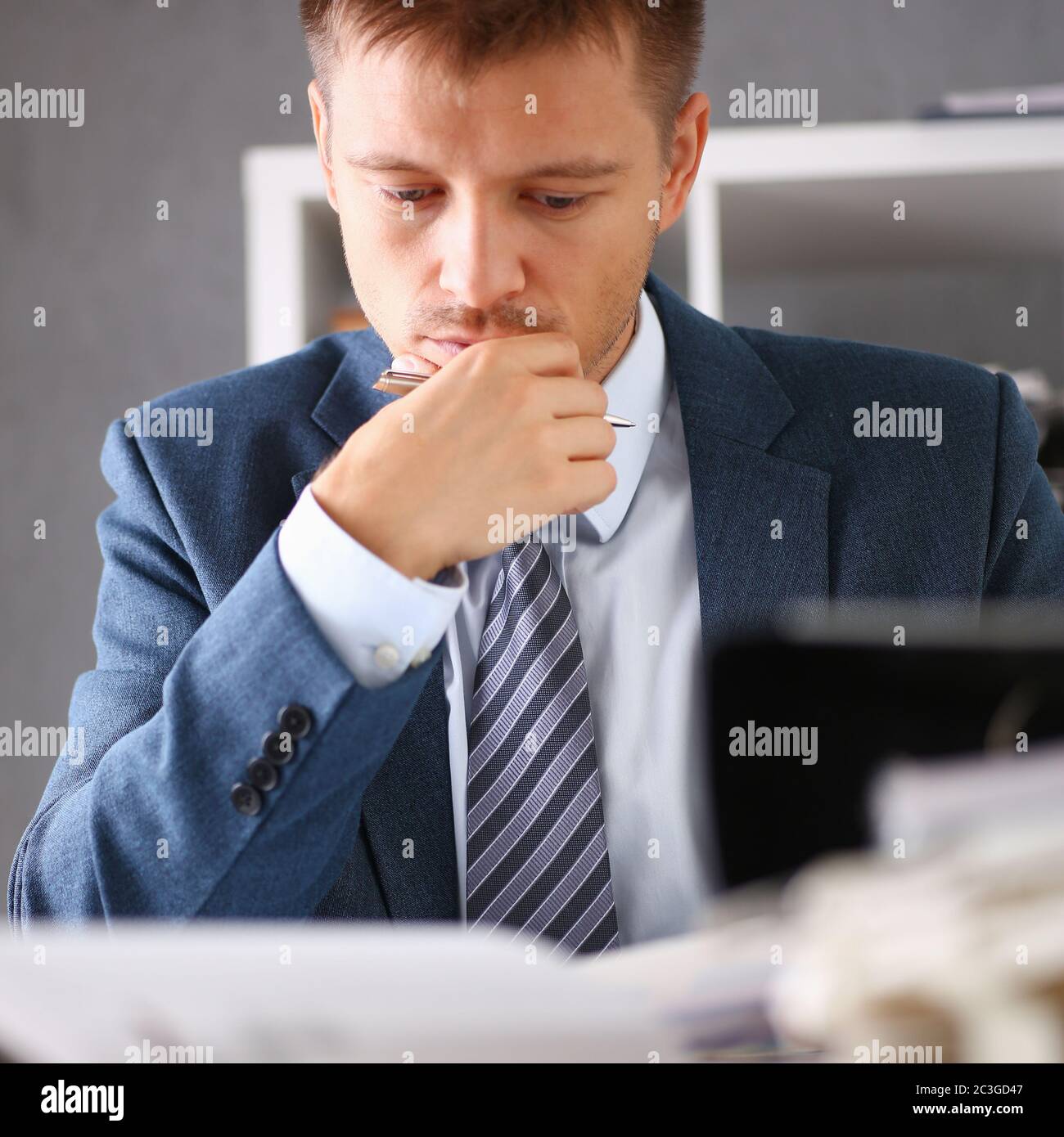 Serious businessman in the office examines documents Stock Photo