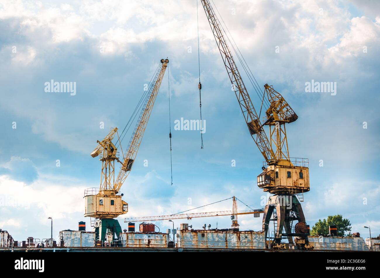 Two rusty abandoned cargo cranes in the city old industrial area Stock Photo