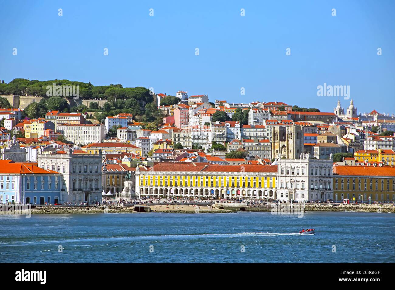 Multi coloured buildings of the old city of Lisbon. São Jorge Castle above the city and Praça do Comércio town square in the foreground, Portugal. Stock Photo