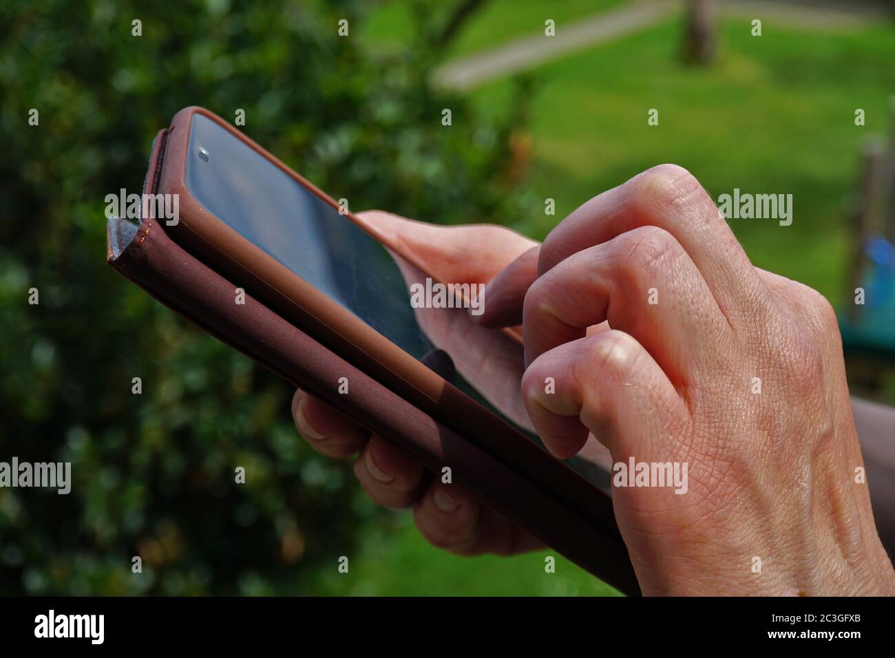 Hand taps into a smartphone Stock Photo