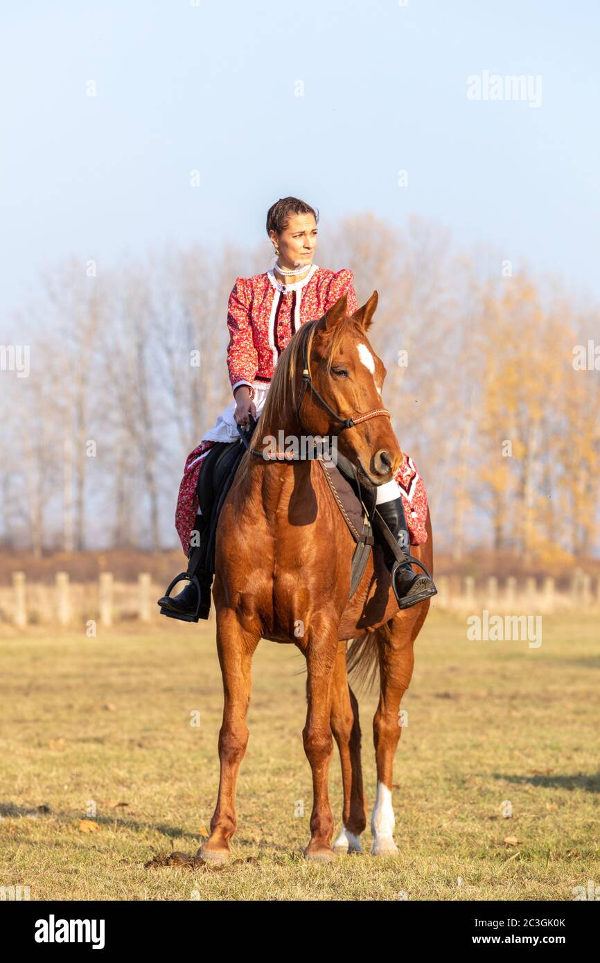 Hungarian csikos horsewoman in traditional folk costume Stock Photo