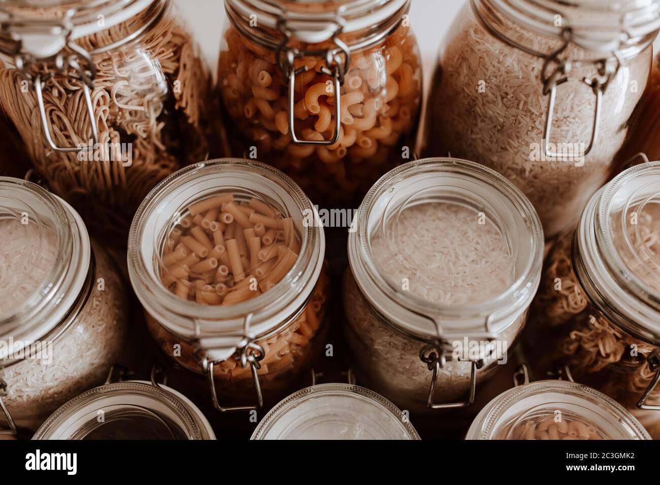 Glass jars full with dried uncooked food ingredients Stock Photo