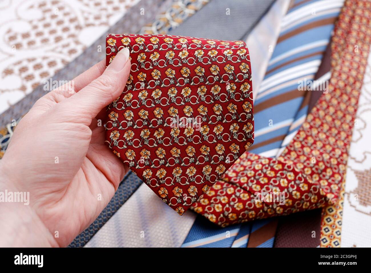 The woman is holding a man's tie in her hand. Man's fashion Stock Photo