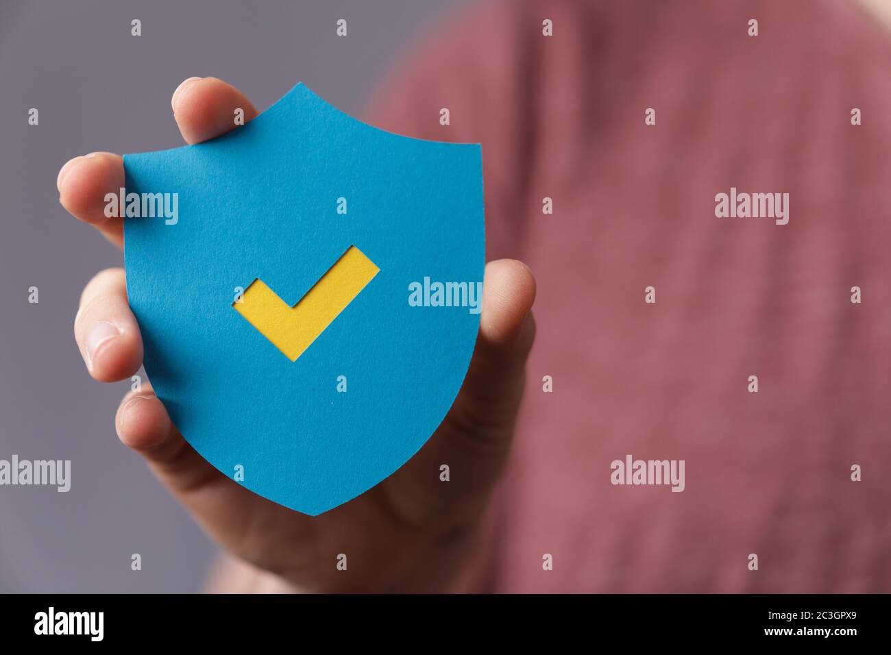 Man holding a protection shield with a checkmark Stock Photo
