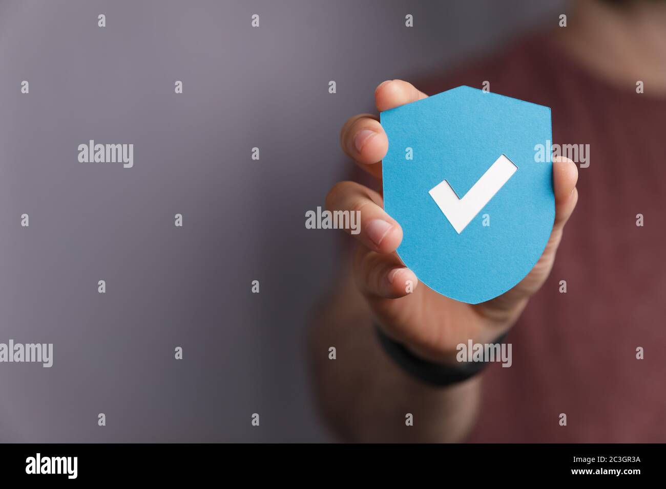 Man holding a protection shield with a checkmark Stock Photo