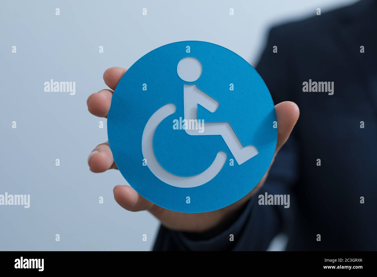 Man holding a circle sign with a disability symbol Stock Photo - Alamy
