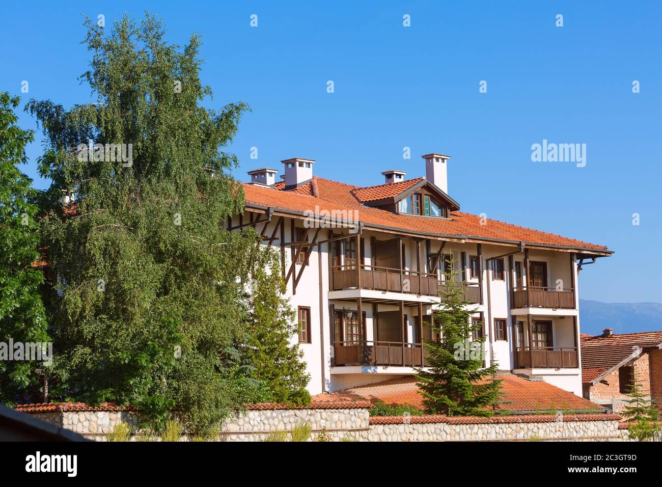 Chalet houses and summer trees, Bansko, Bulgaria Stock Photo