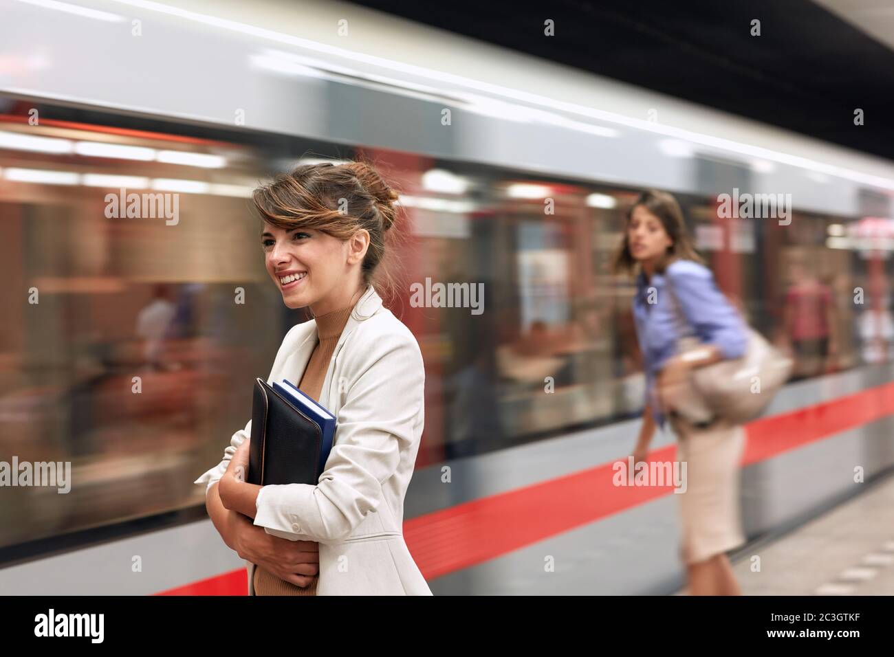 Smiling business young woman waiting for metro in subway.traveling at work. Stock Photo
