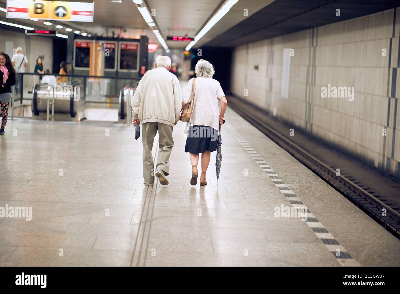 Older happy couple walking together on subway station Stock Photo