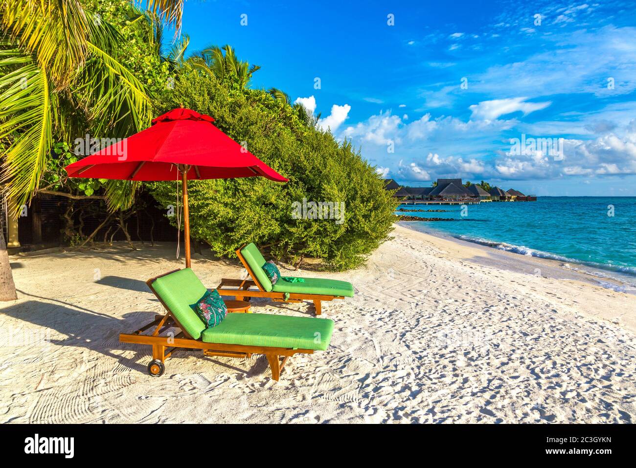 MALDIVES - JUNE 24, 2018: Wooden sunbed and umbrella on tropical beach