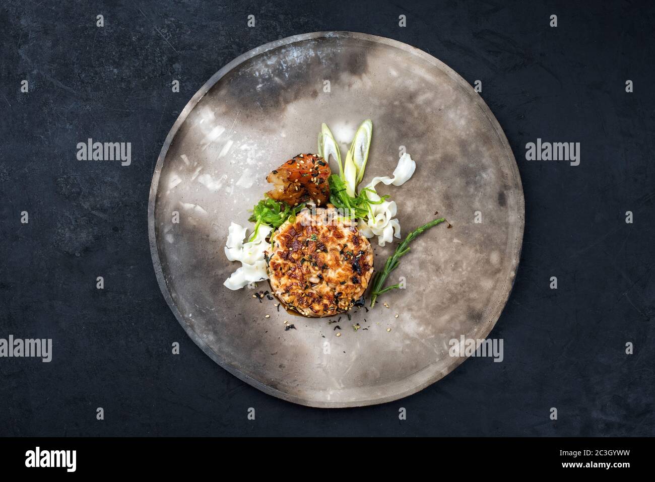 Japanese gourmet salmon fish tartar raw from salmon fillet with king prawns and noodles with spices as top view on a modern desi Stock Photo