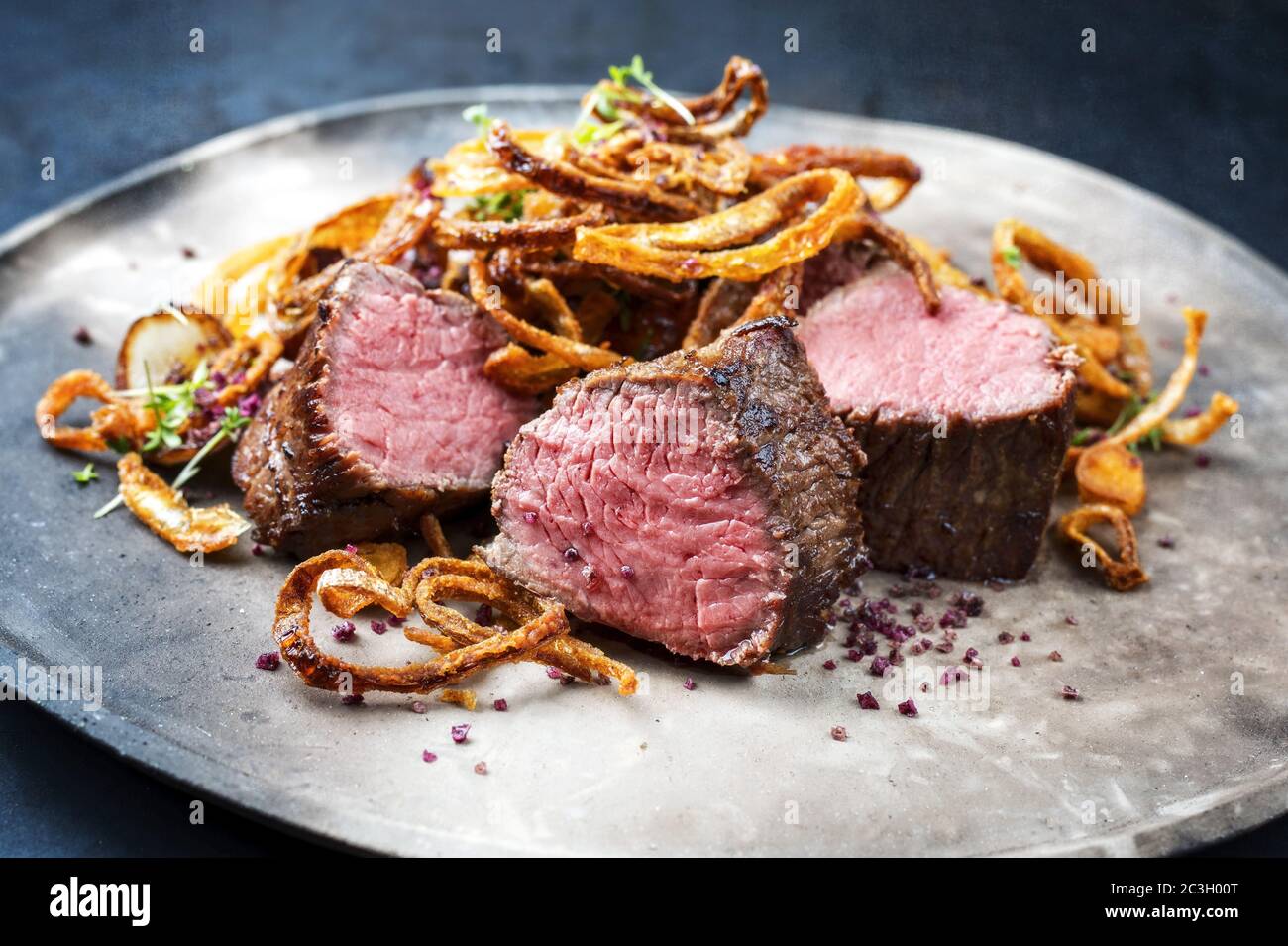 Traditional dry aged sliced beef tenderloin with fried onion rings and