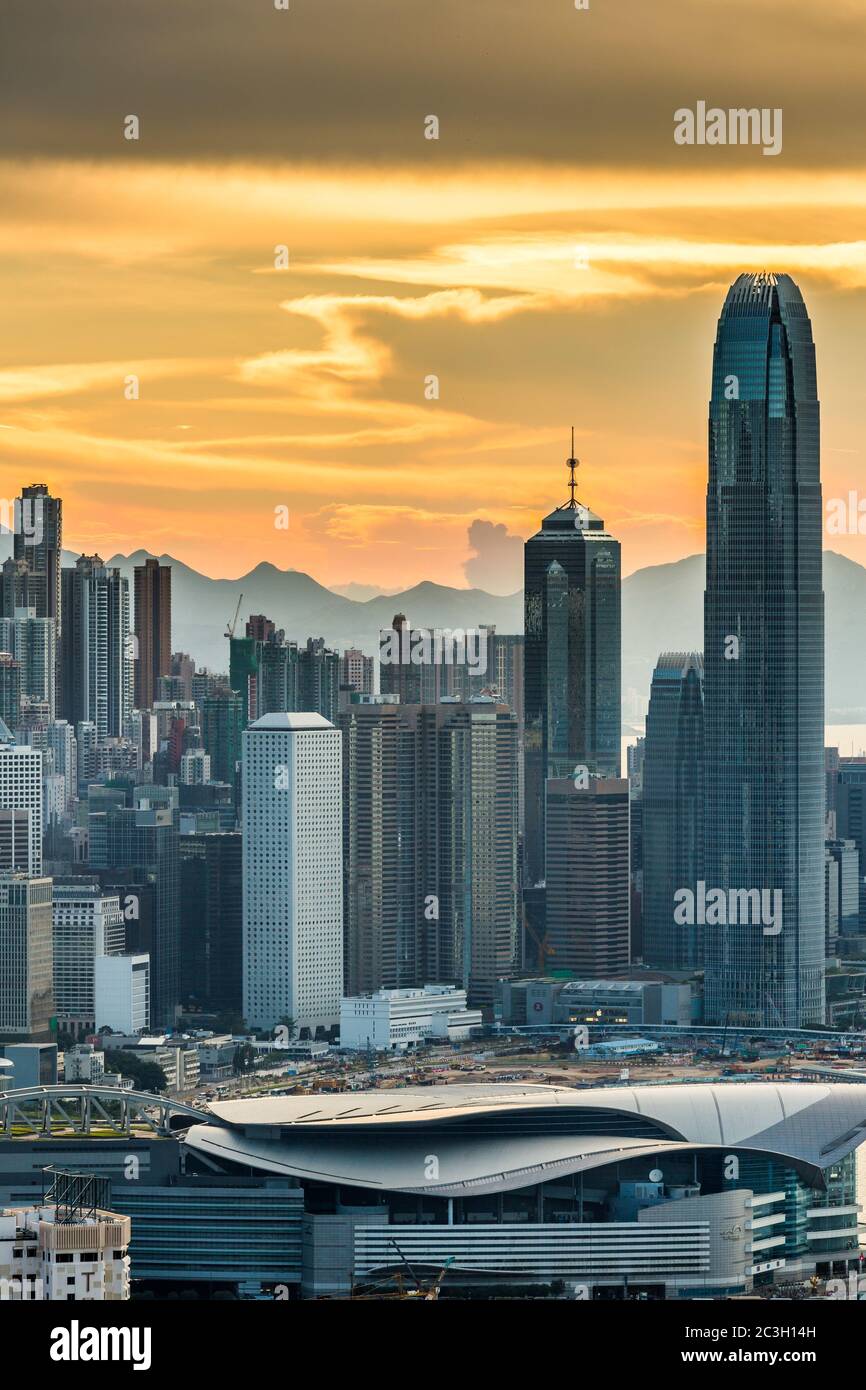 Vertical shot of Skyscrapers in Hong Kong under an orange sky at sunset Stock Photo