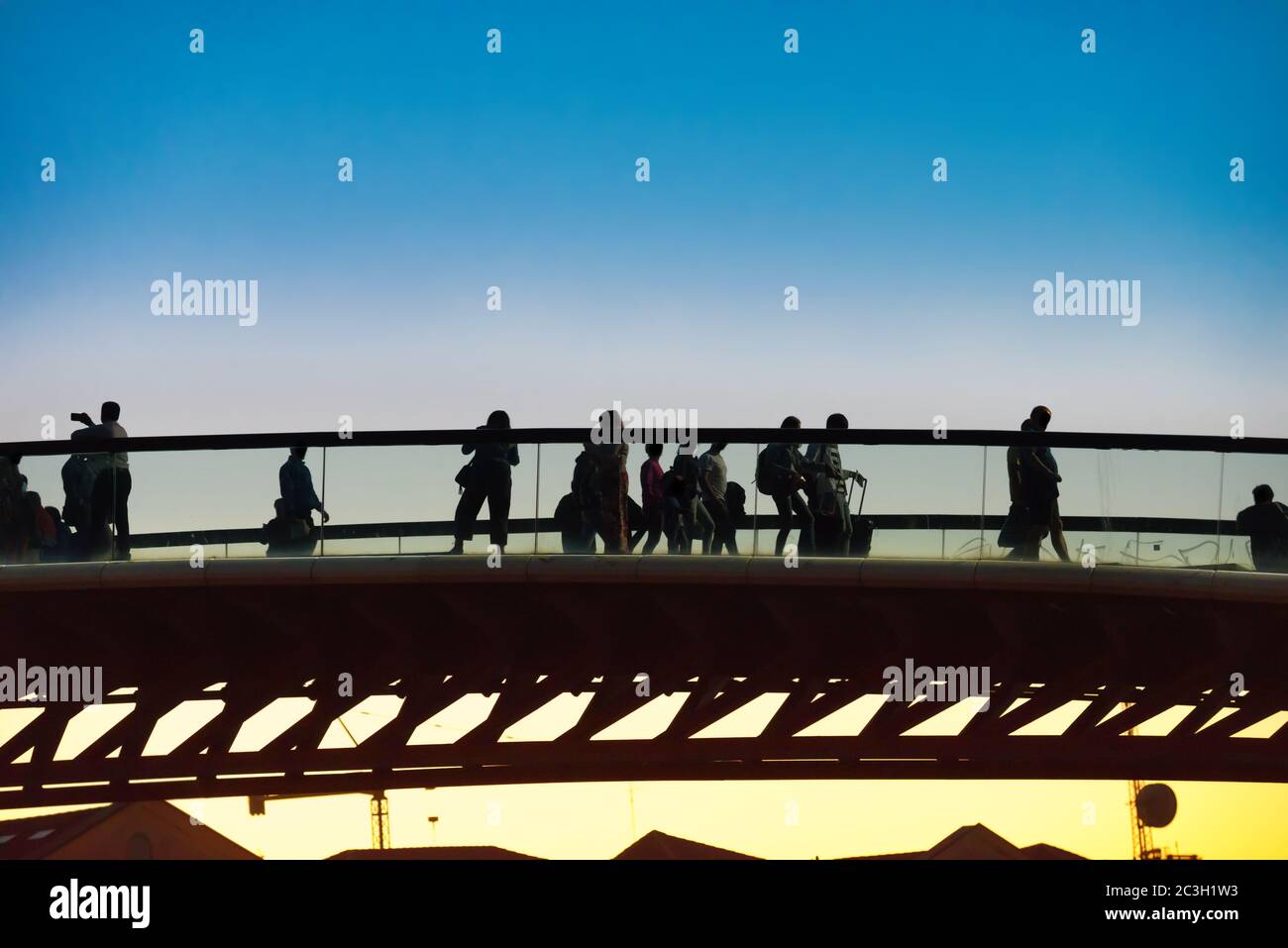 Silhouette of walking people on bridge Stock Photo - Alamy