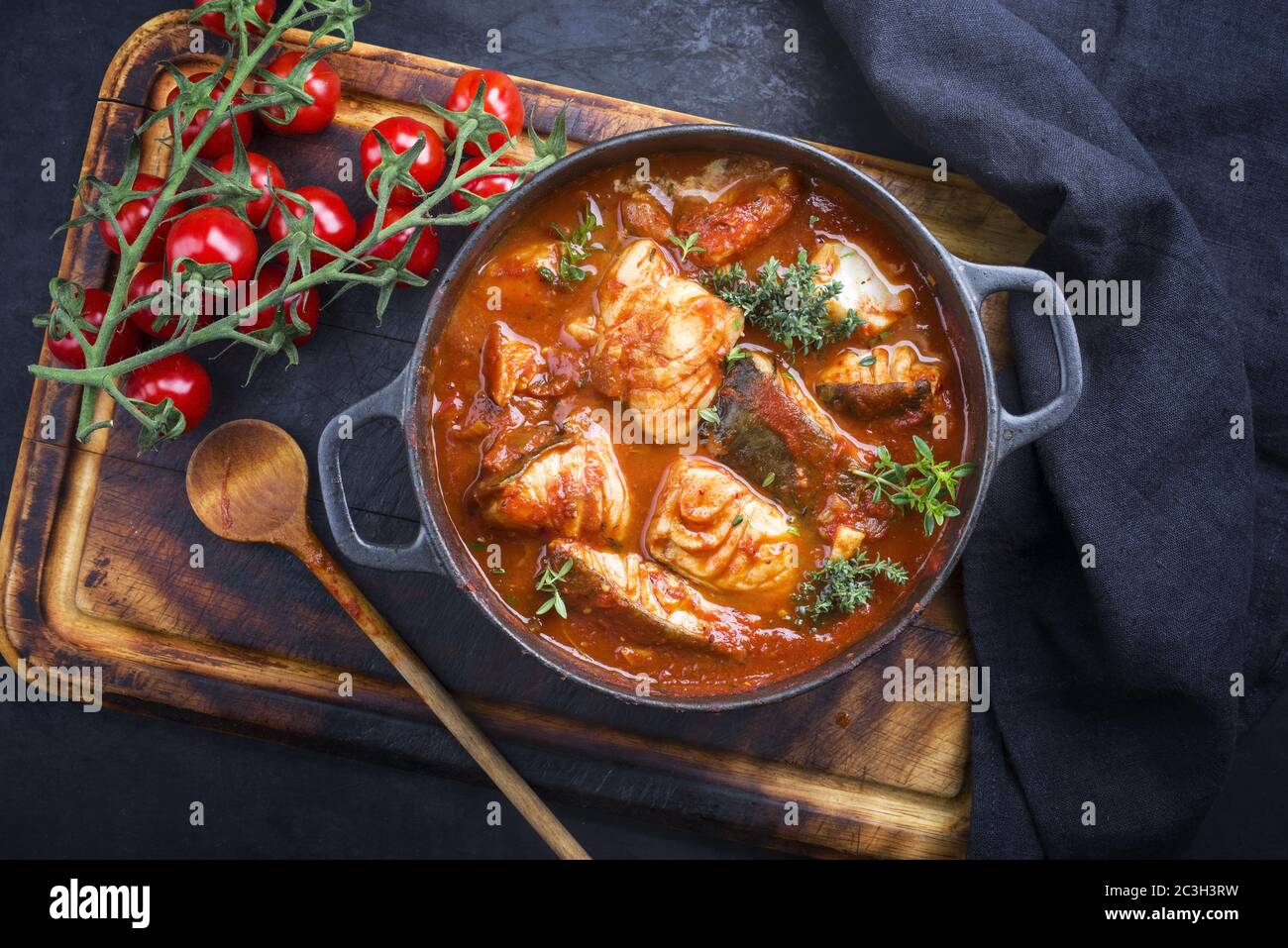 Traditional Brazilian fish stew moqueca baiana with fish filet in tomato sauce as top view in a