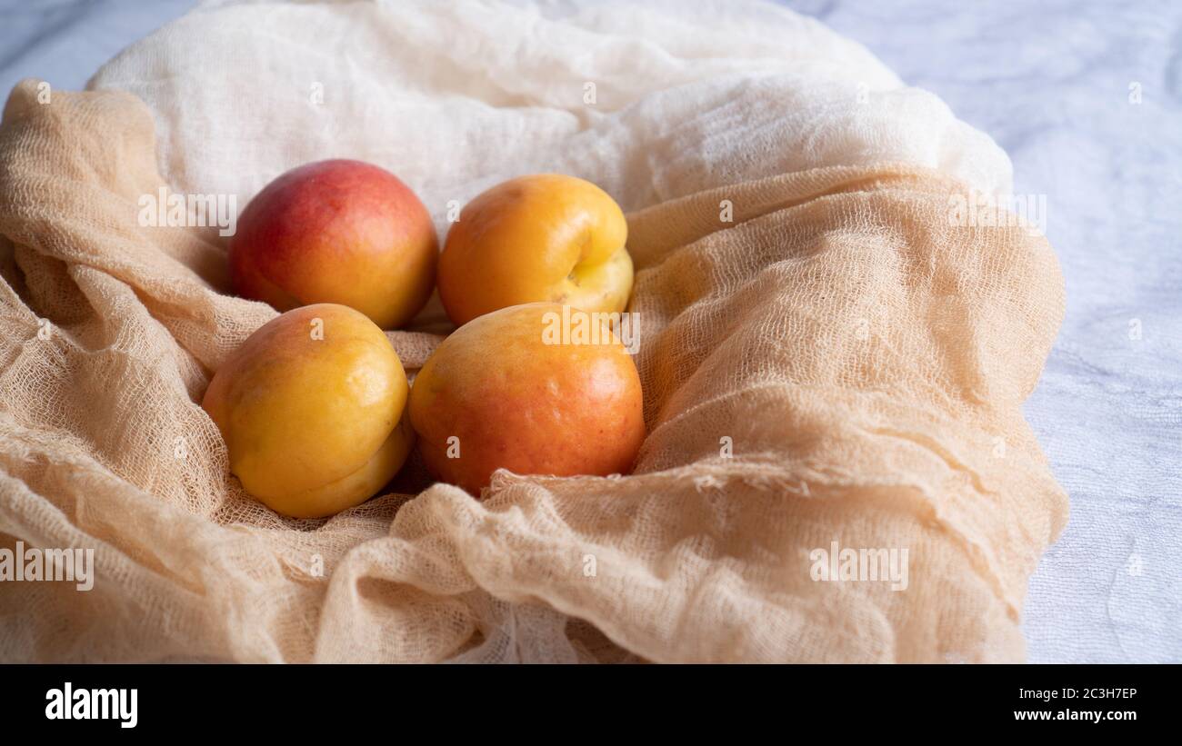 apricots on a soft and light fabric. a few apricots. bunch of apricots in gauze. High quality photo Stock Photo