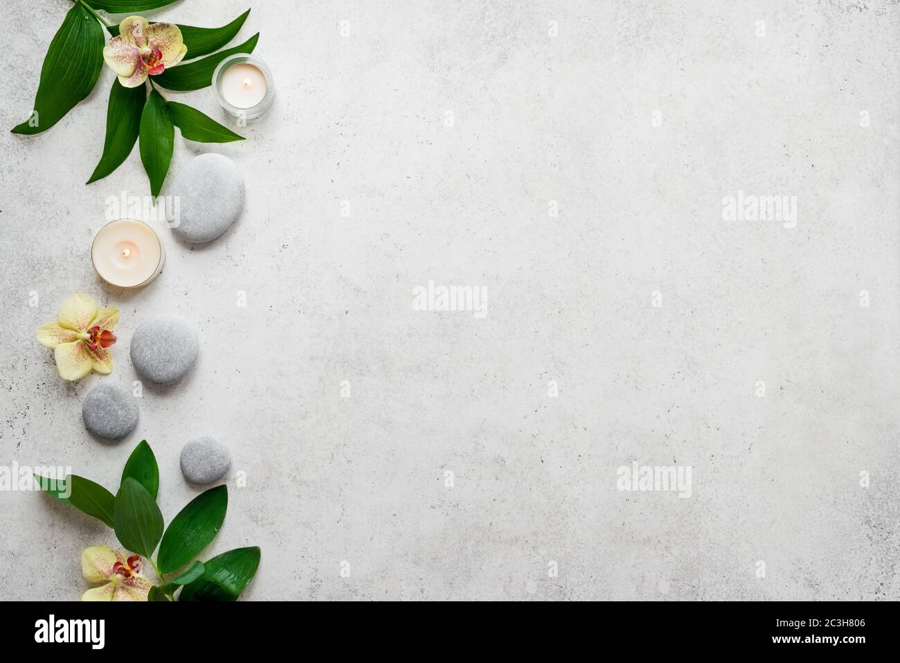 Spa concept on white stone background, tropical leaves, flowers, candle ...