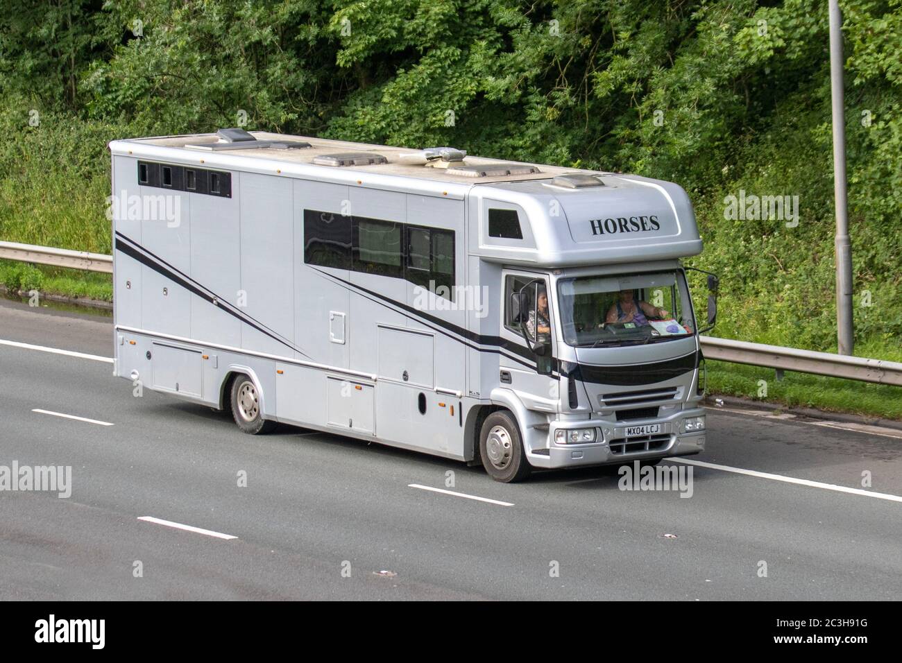2004 white Iveco-Ford horsebox van; Coach built and conversion Animal transport travelling on the M6 motorway, Lancashire,UK Stock Photo