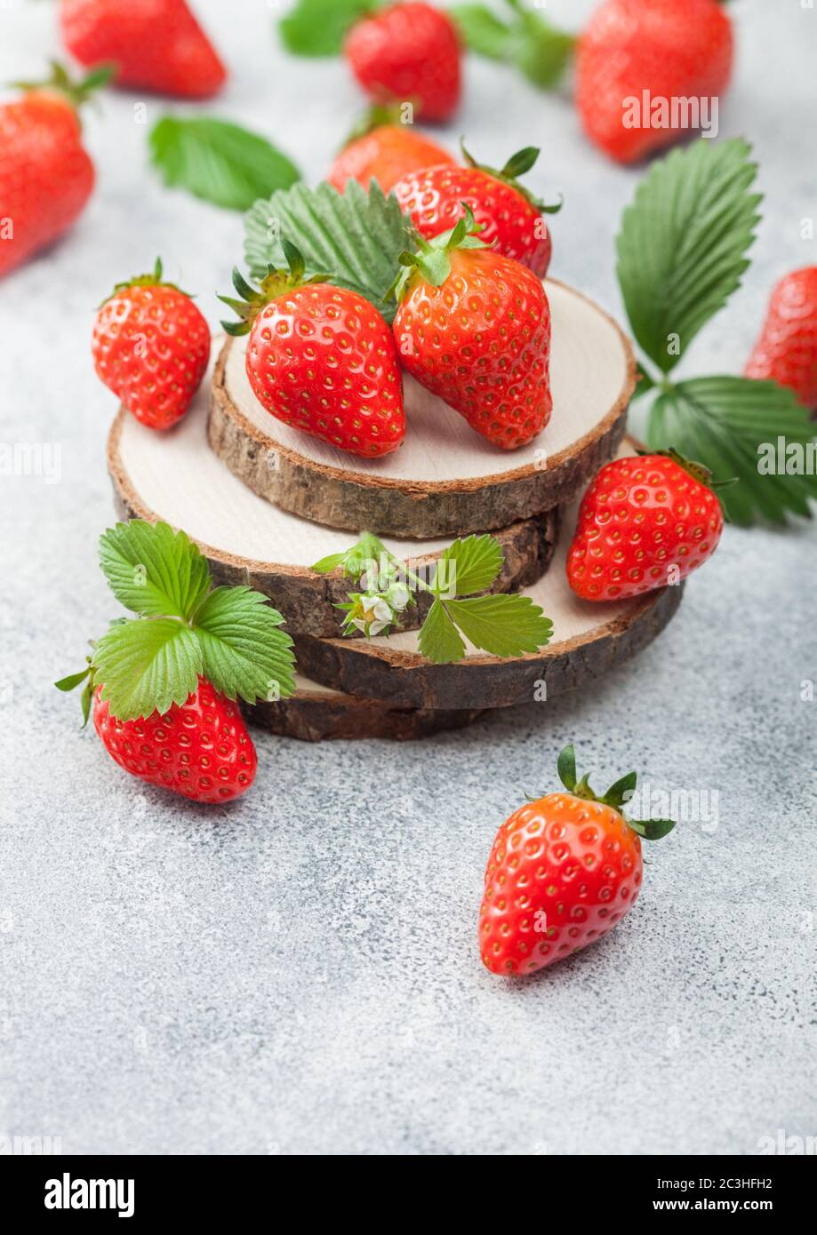 Organic fresh raw strawberries with leaf on timber round boards on ...