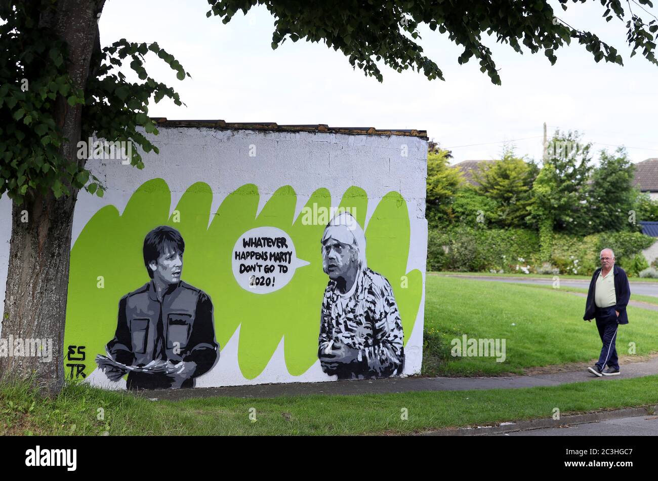 A man walks past Irish artist Emmalene Blake's mural of characters Marty McFly and Doc Brown from the cult 80's movie 'Back to the Future' in South Dublin. This is the latest coronavirus themed mural from the Dublin artist during the pandemic. Other artists featured have been Dua Lipa, Robyn and Cardi B. Stock Photo