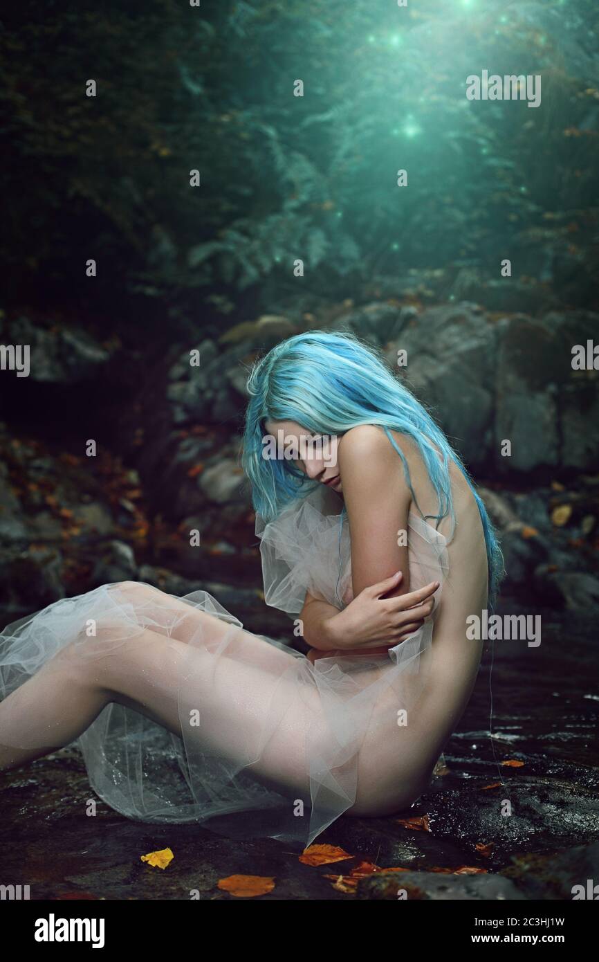 Beautiful woman feeling alone in fairy forest. Fantasy and halloween Stock Photo
