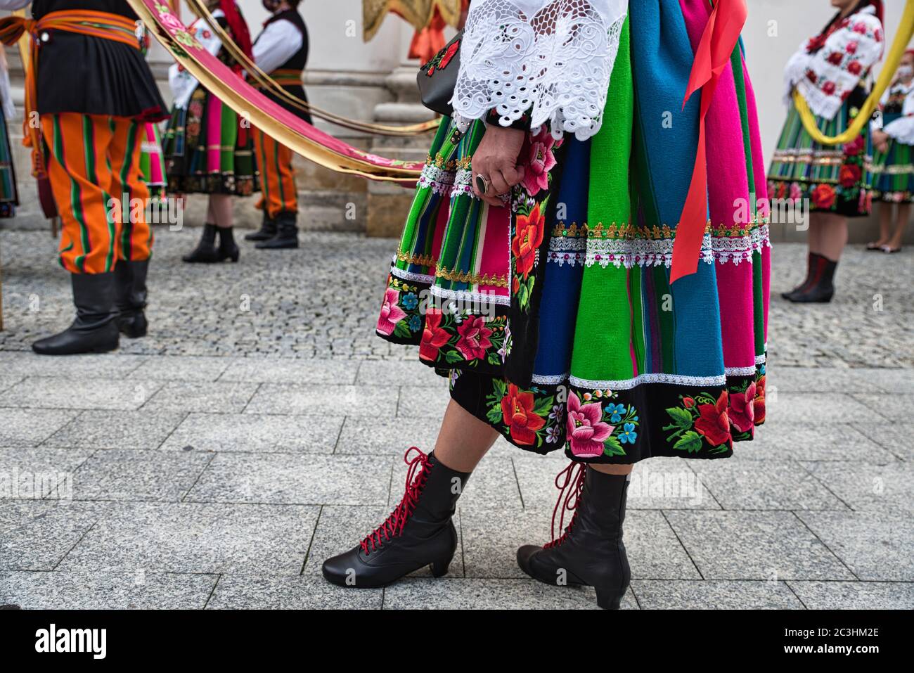 People dressed in polish national folk costumes from Lowicz region during annual Corpus Christi procession. Close up of traditional striped skirt Stock Photo