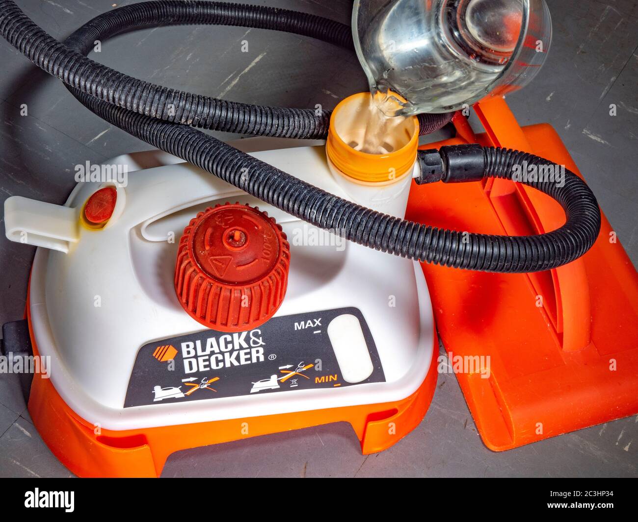 https://c8.alamy.com/comp/2C3HP34/water-being-poured-into-the-filler-cap-of-a-black-decker-orange-and-white-plastic-wallpaper-stripper-with-associated-hose-and-steam-plate-2C3HP34.jpg
