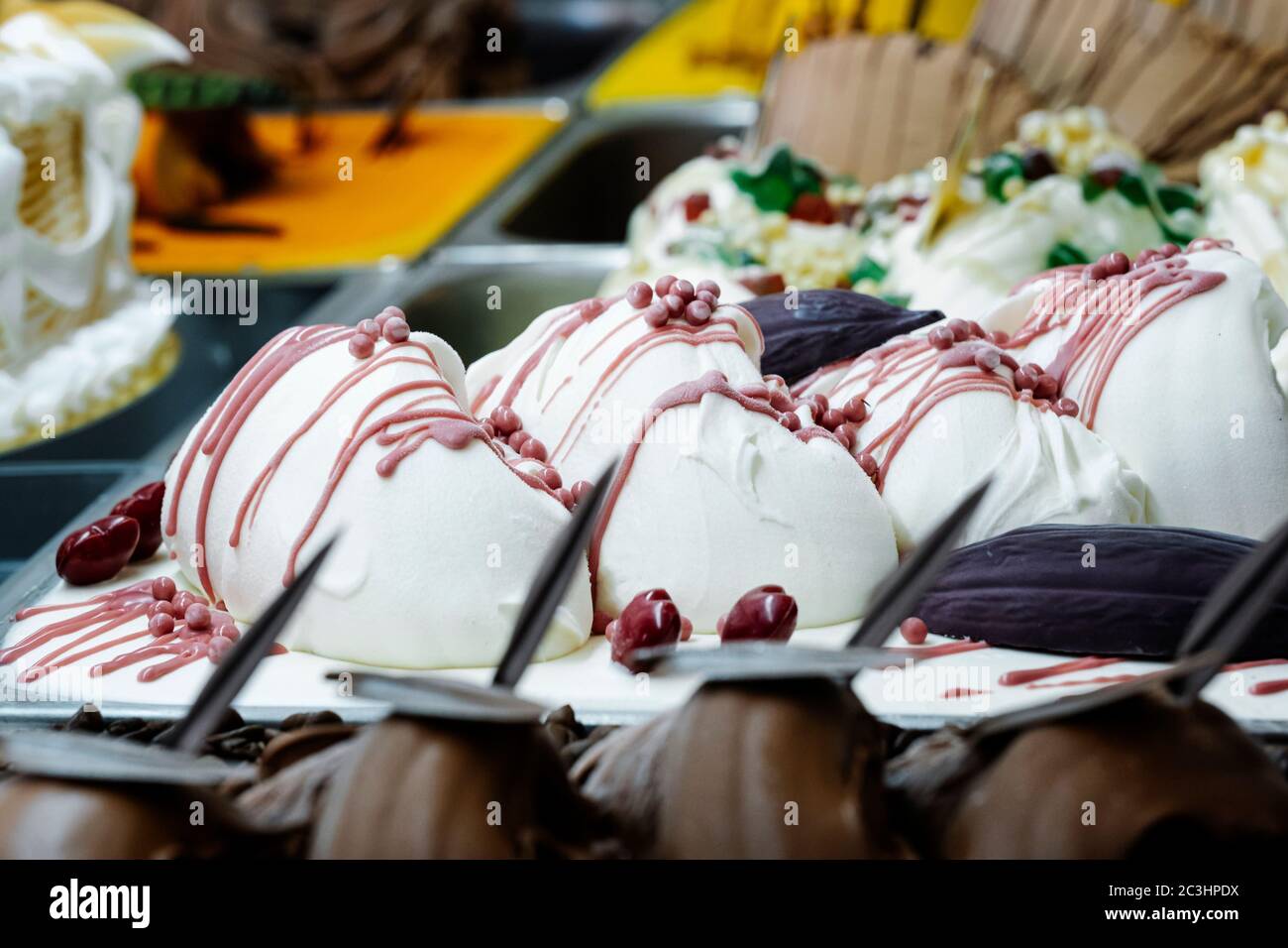 Strawberry cream ice cream in a display case with different ice cream tubs Stock Photo
