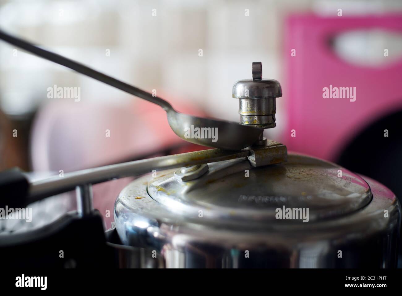 https://c8.alamy.com/comp/2C3HPHT/pressure-cooker-in-an-indian-kitchen-with-the-whistle-pressure-release-valve-held-open-with-a-spoon-2C3HPHT.jpg