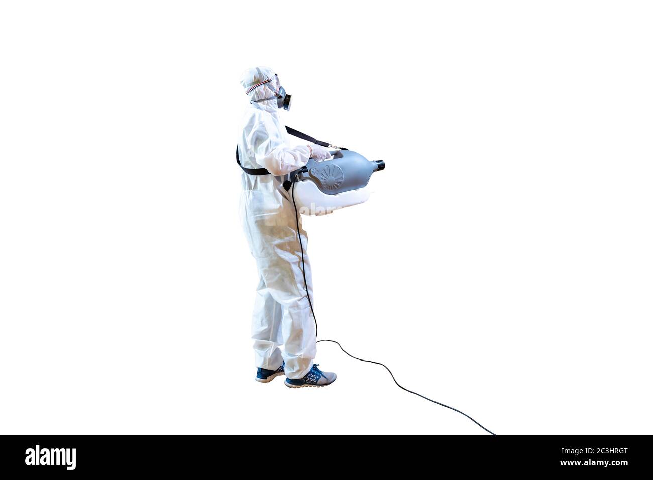 Professional technical man in prevention suit sprays sterilising solution by electrical spray machine on wood floor and white background with studio l Stock Photo