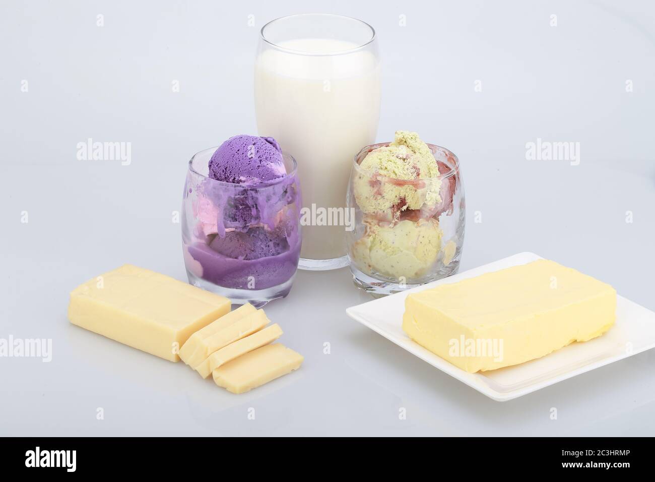 Butter, cheese, ice cream in glasses and a glass of milk isolated on a ...